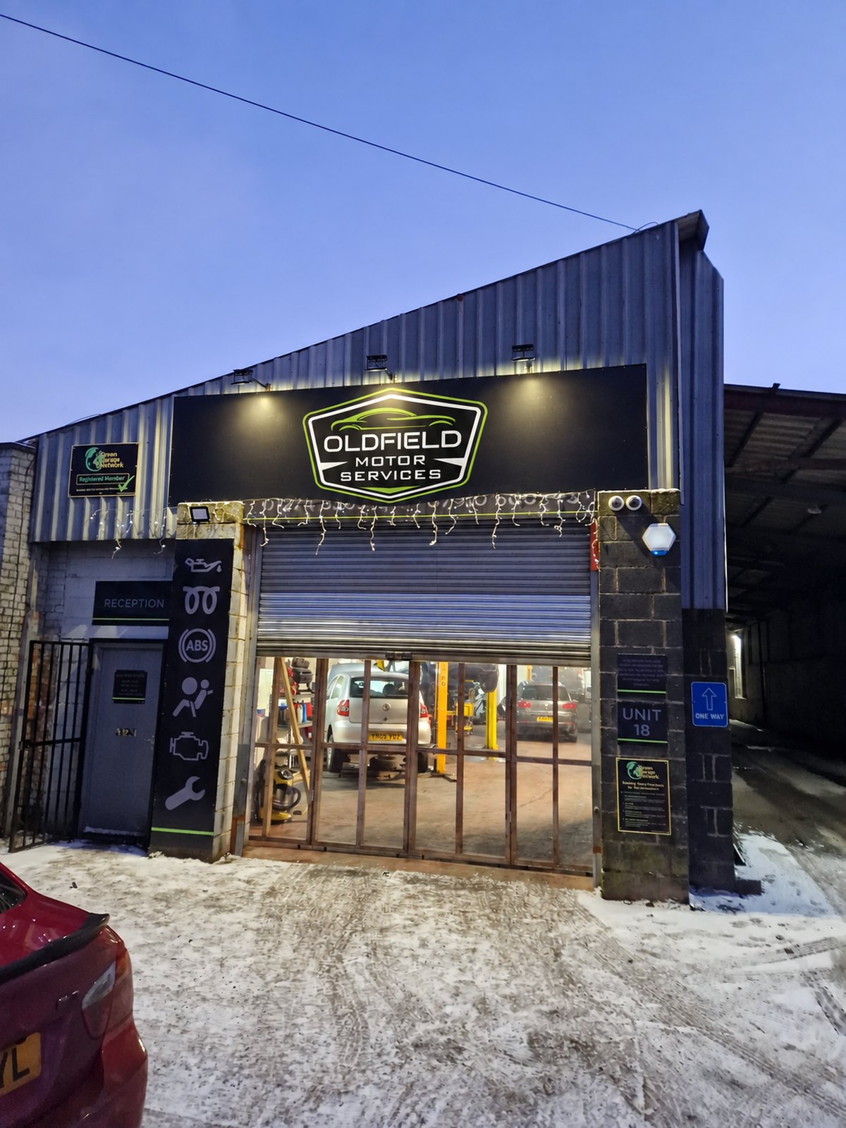 The Oldfield Motor Services unit at dusk, with the Green Garage Network registered member sign