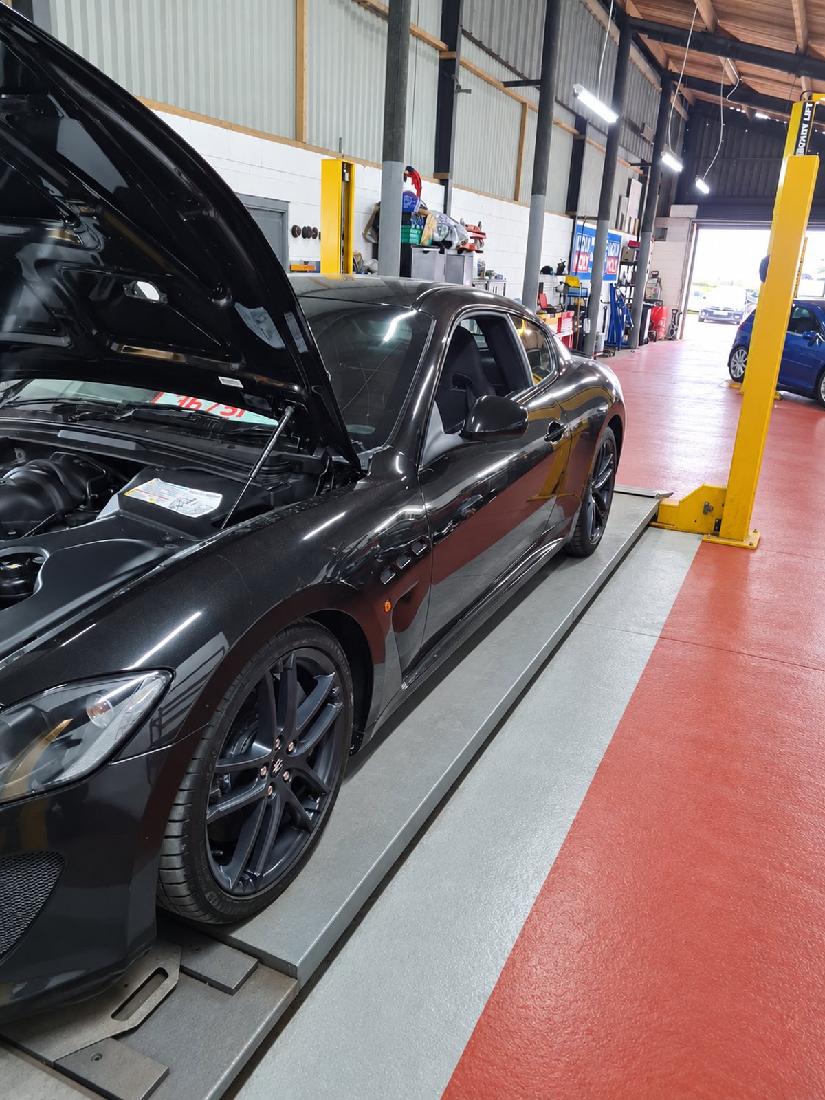 Black Maserati on the ramp in the workshop