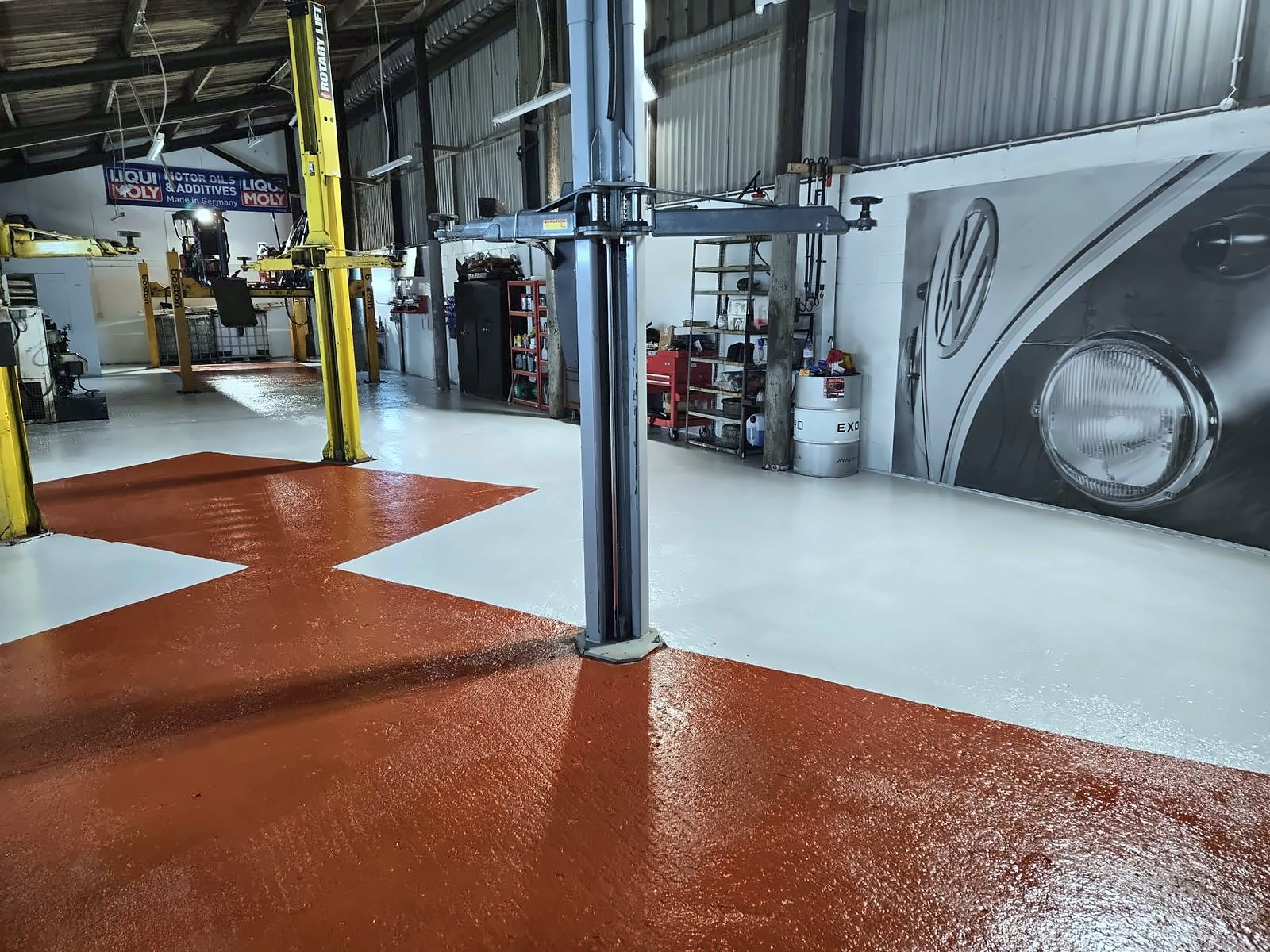 Freshly painted workshop floor with a two-post lift